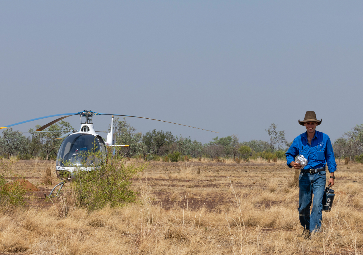 Two men in blue shirts are in a helicopter. Description generated by AI