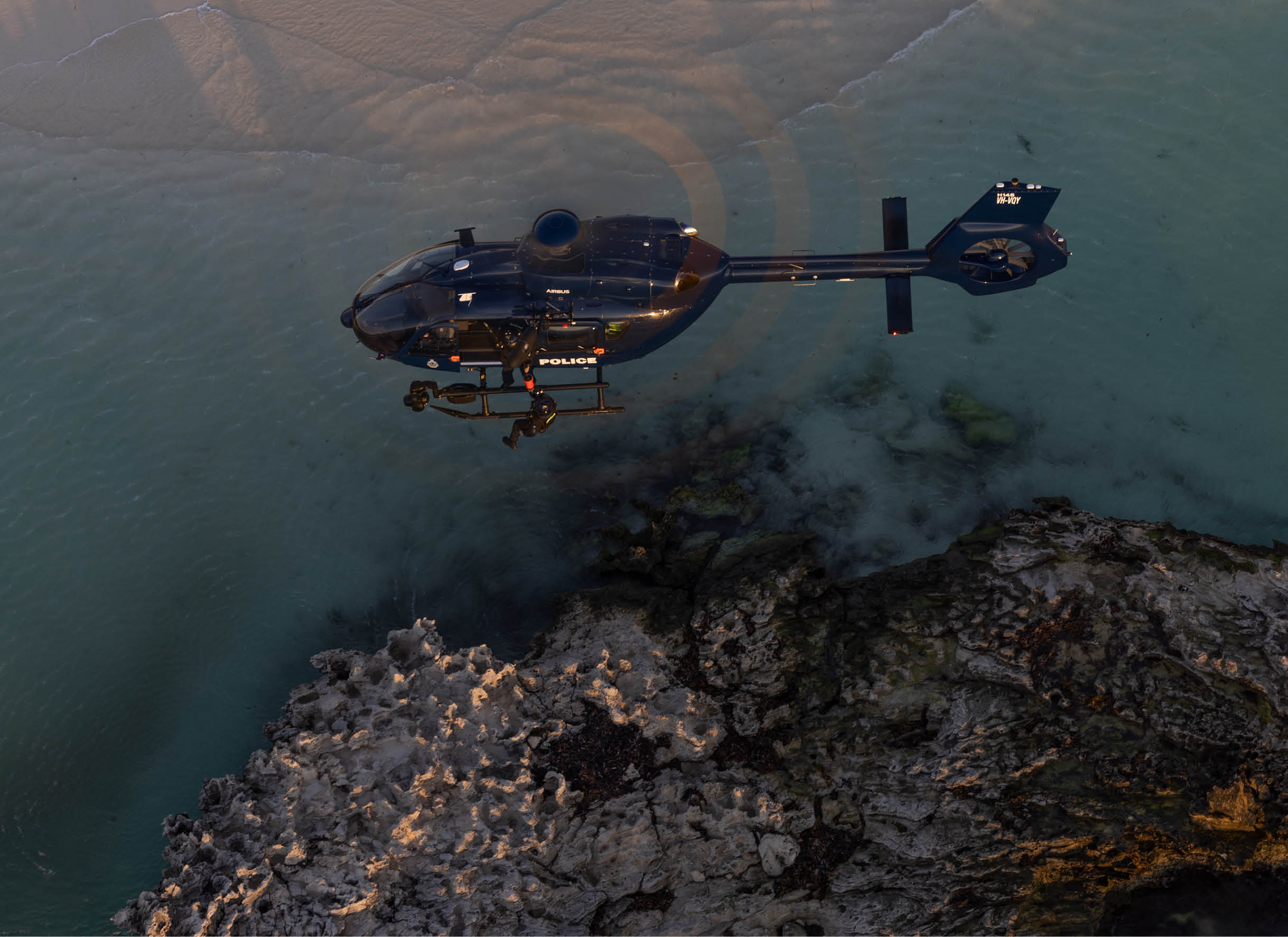 Two helicopters on a beach. Description generated by AI