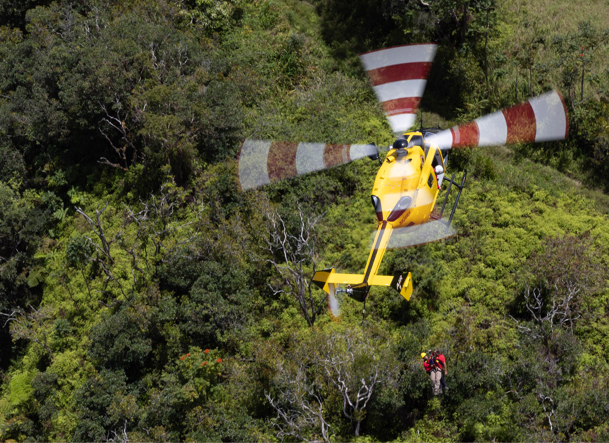 A helicopter is flying over a rock formation. Description generated by AI