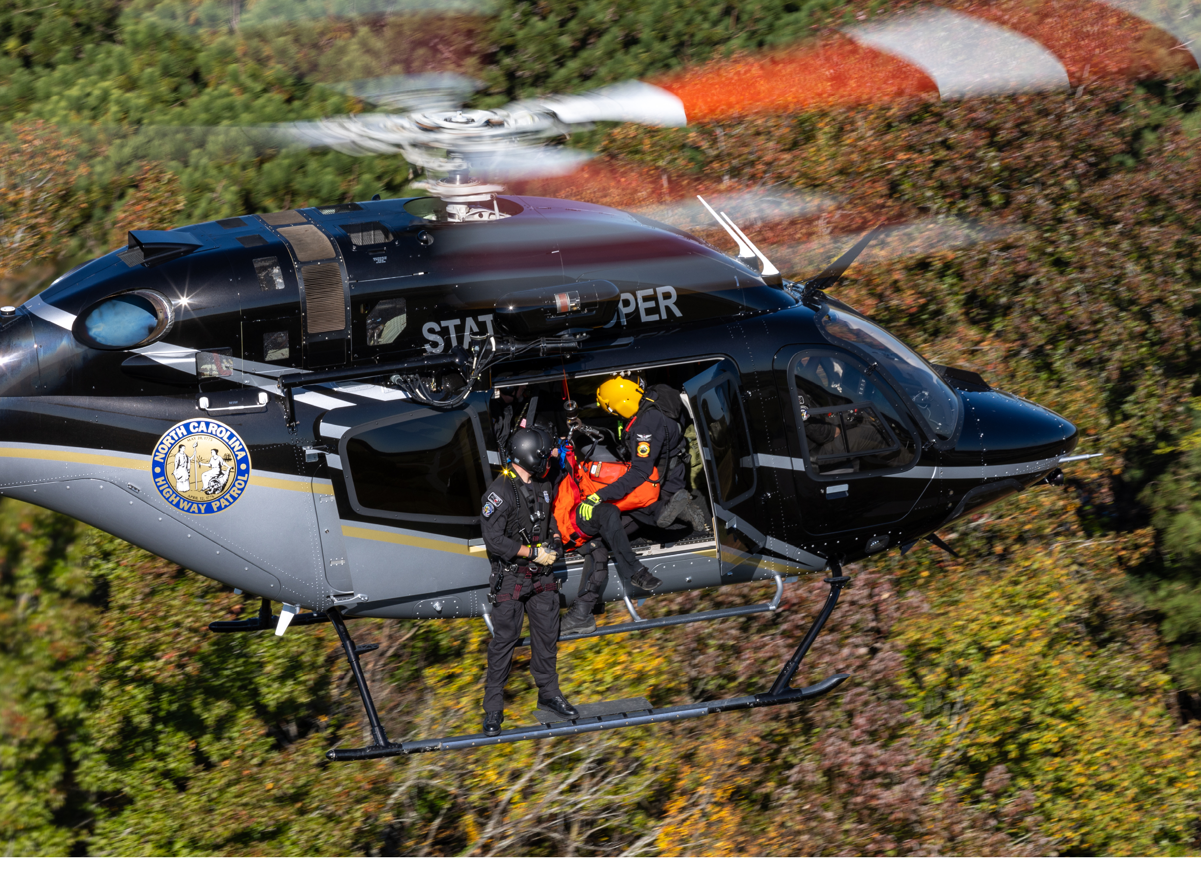 Two helicopters flying in the sky. Description generated by AI