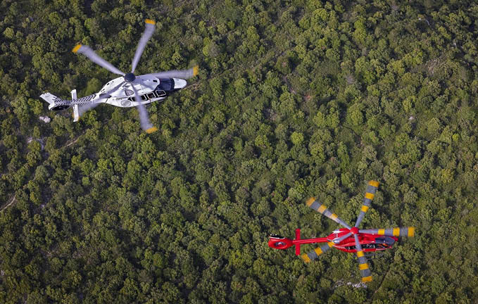 A blue helicopter flying in the air. Description generated by AI