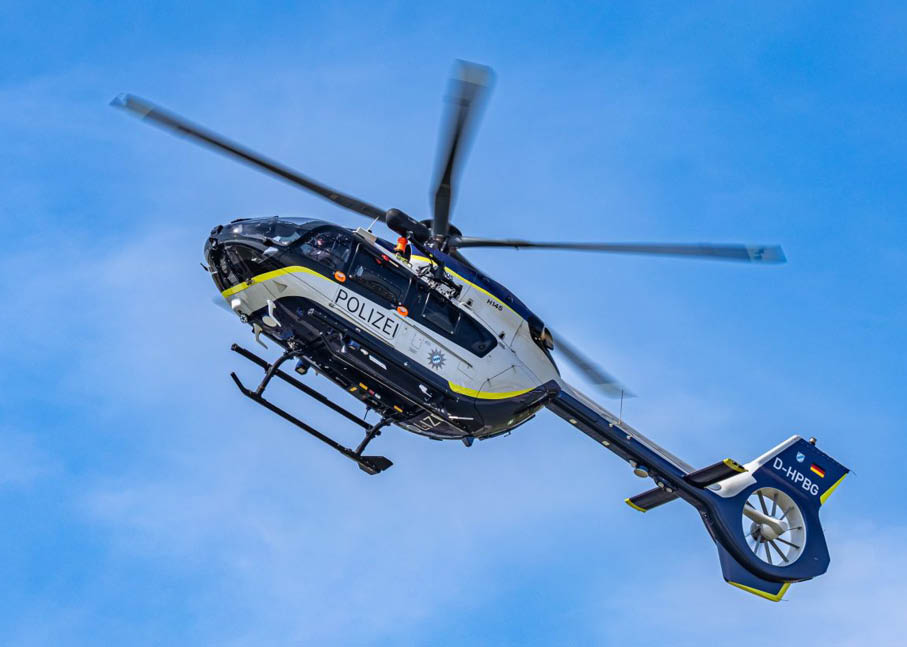 A helicopter flying above a mountain. Description generated by AI