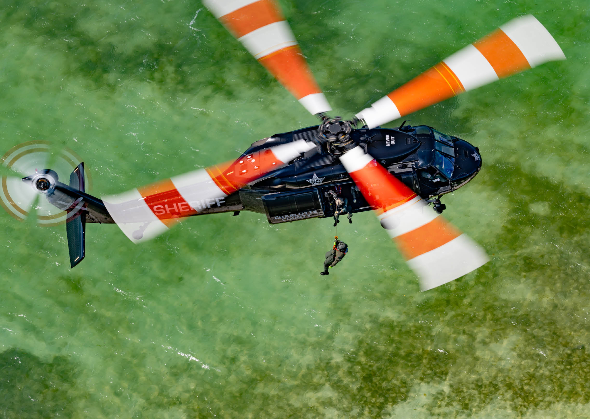 A helicopter flying over a body of water. Description generated by AI