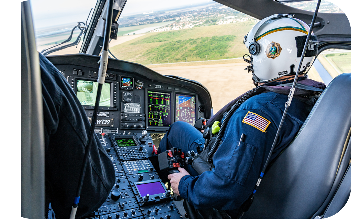 A helicopter is flying over a field. Description generated by AI
