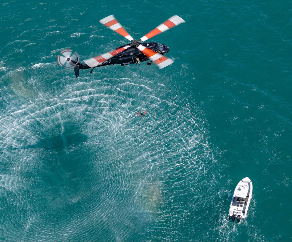 A helicopter flying over a bridge. Description generated by AI