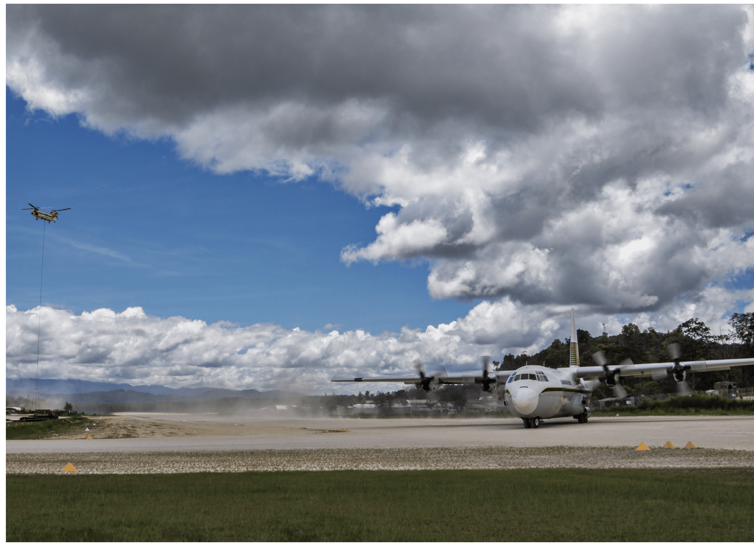 A propeller airplane is taxiing on a runway under a cloudy sky with a drone flying nearby. Description generated by AI