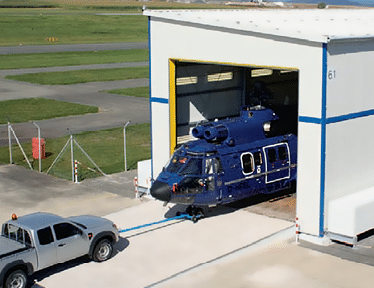 A blue truck is being loaded into a large building. AI generated content