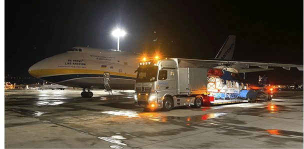 A large airplane is parked on the runway, and a truck is nearby, possibly unloading cargo. AI generated content