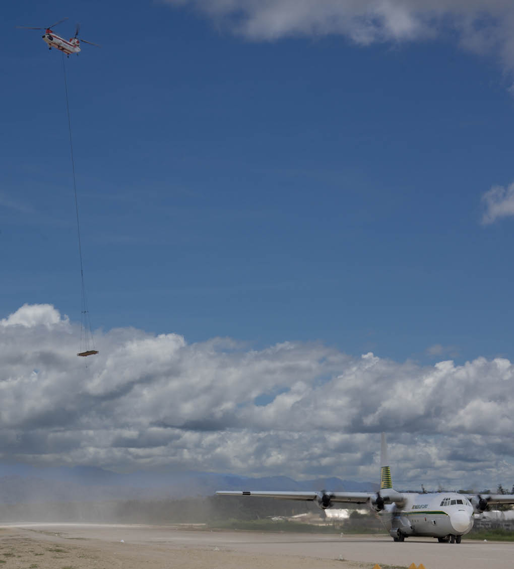 A helicopter is flying in the sky with a long cable hanging down from it. Description generated by AI