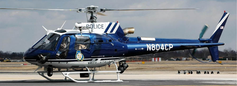 A blue and white police helicopter with the registration number N804CP is parked on a tarmac under a cloudy sky. Description generated by AI