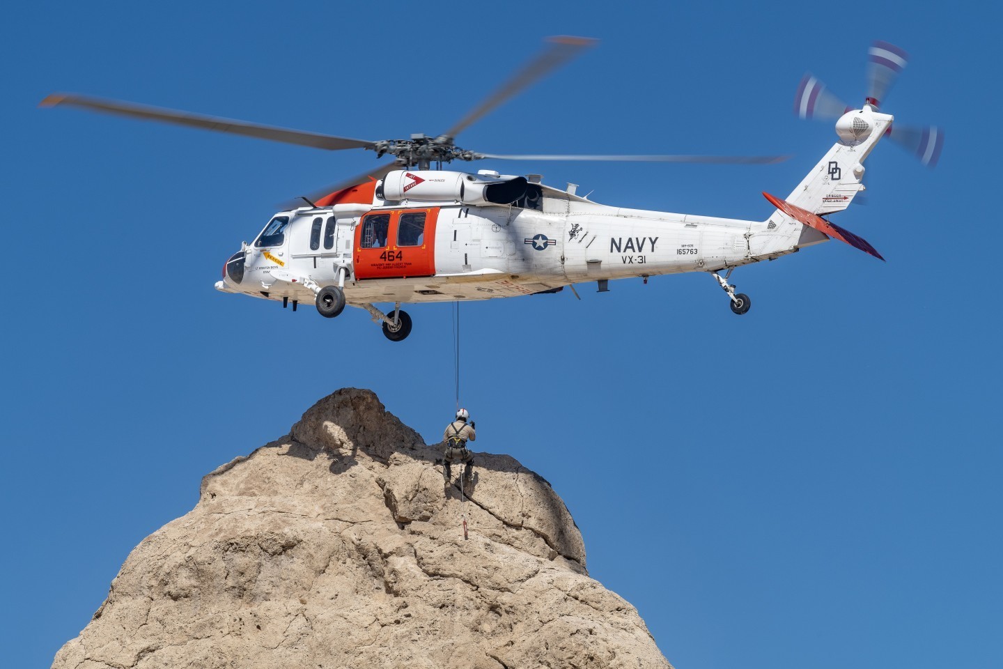 Naval Air Weapons Station China Lake Search and Rescue MH-60S Blackhawk practices out in the Southern California desert. A crew member is
lifted up along a rock formation as the skilled pilots hover above.