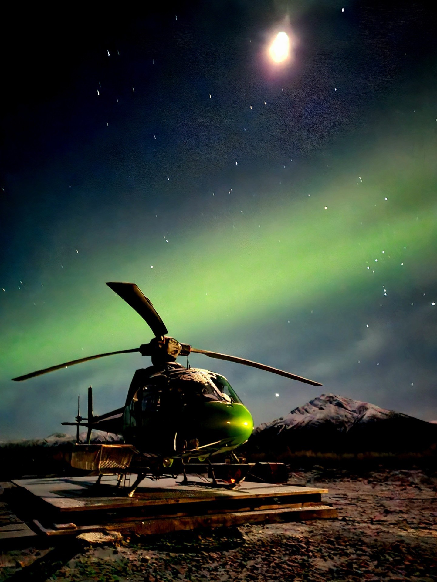 Yukon drill camp central yukon 5.30am with faint Aurora overhead. Horizon Helicopters AS350SD2 about to get preflight inspection before
support to 3 fly drills on gold exploration. This morning was the first clear sky after 10 days of early fall overcast cloud and snow
conditions -12 deg Celsius