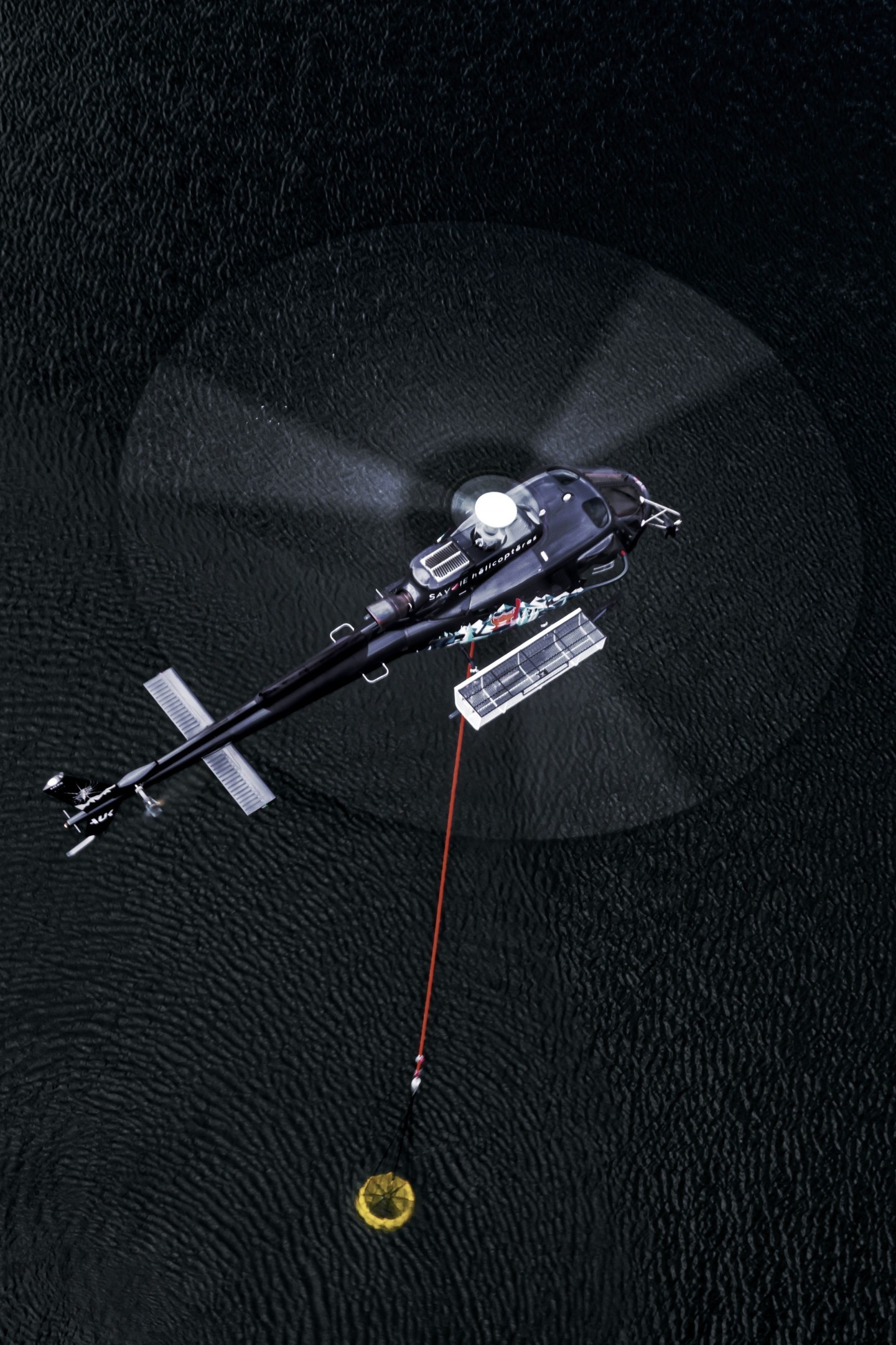 I captured this H125 from Savoie Hélicoptères during an air-to-air shoot. We're in the French Alps on a fire-fighting training mission. We had the opportunity to practice for a long time, which prompted me to try a “full disc”, which worked out quite well - you can see the helicopter and bucket in the water through the rotor disc.