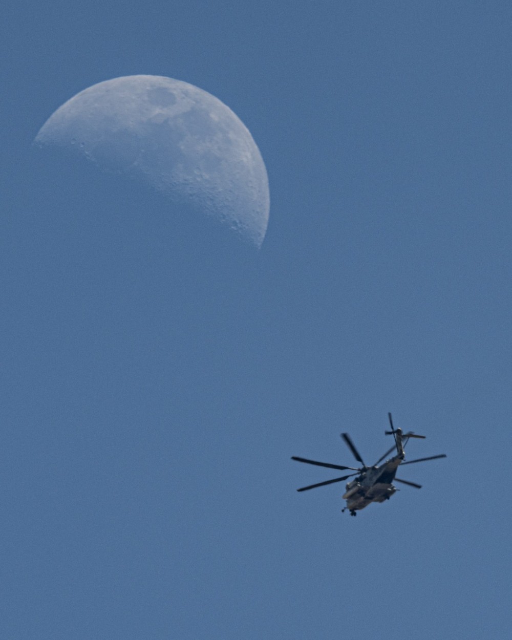 HMH-466 Wolfpack CH-53E, passing by on their way from USMC  Mountain Warfare Training Center, heading home to MCAS Miramar. There was a flight of three, I was lucky enough to catch one passing by the moon.