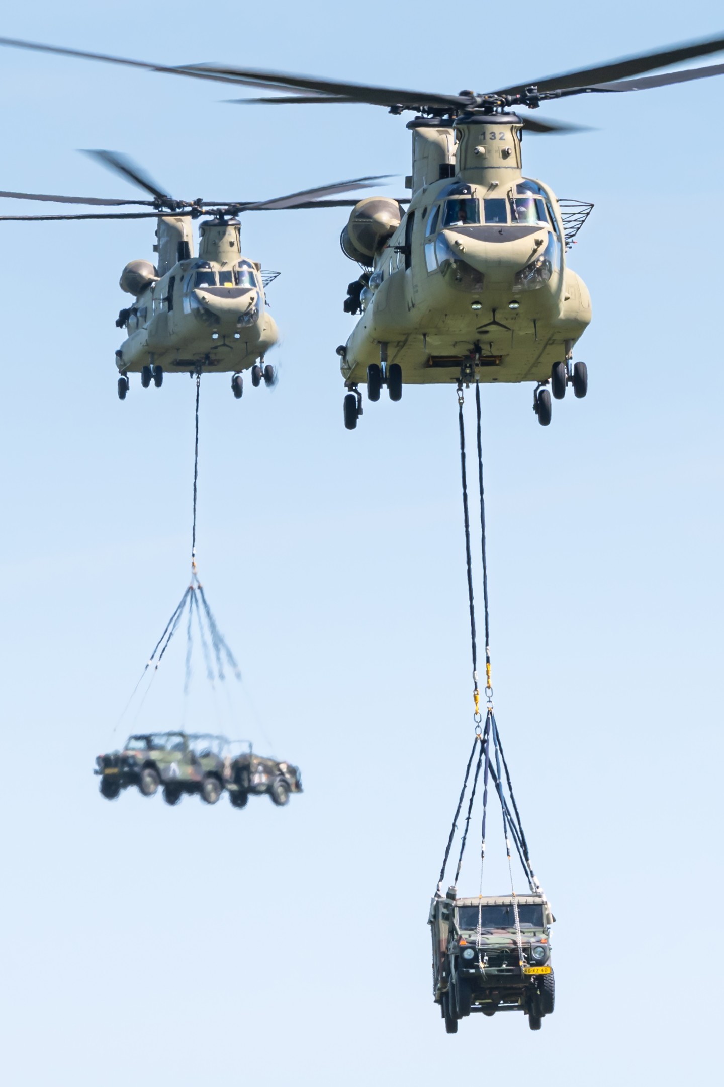 Two Boeing Chinook helicopters from the 11th Airmobile Brigade of the US Army lifting military vehicles during the large-scale exercise Falcon Spring in The Netherlands.