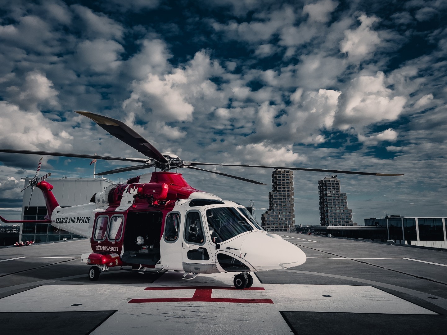 Landed at the Karolinska University hospital rooftop helipad in Stockholm with a patient after a medevac from a vessel off shore. Dramatic clouds with a crisp blue skye. Not all rescue missions are in bad weather.