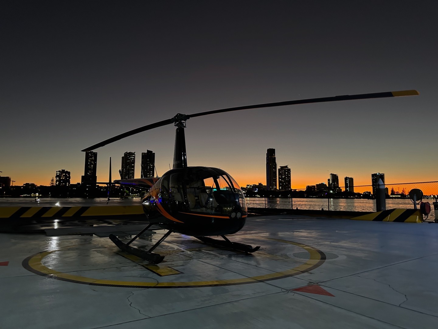 Gold Coast Helitours R44 on the pad at sunset