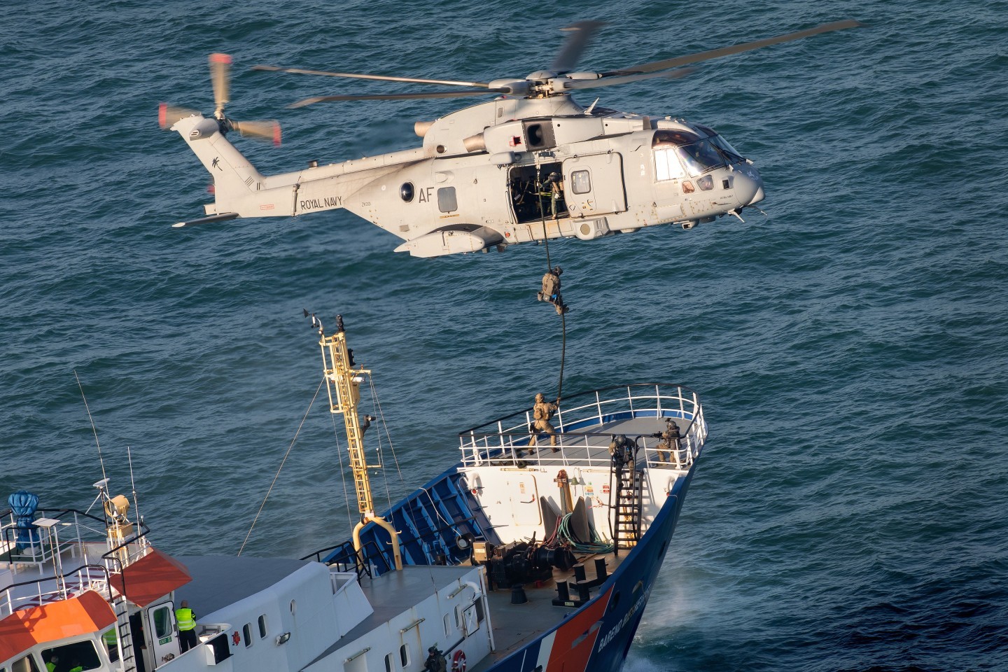 Dutch special forces operators are fastroping from a Merlin of 846NAS during an anti-terrorism training mission over the North Sea, and about to perform a simulated hostage rescue on board of Dutch Coast Guard vessel Barend Biesheuvel.