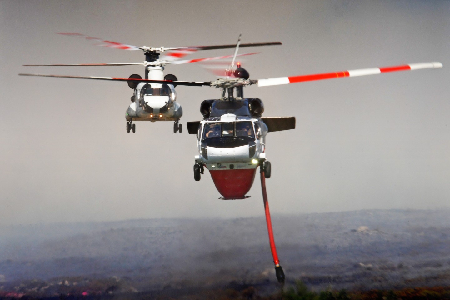 PJ Helicopters Blackhawk 9PJ lifts out of the dip as Coulson's CH47 9CU returns for another load of water while battling the Dale Fire.