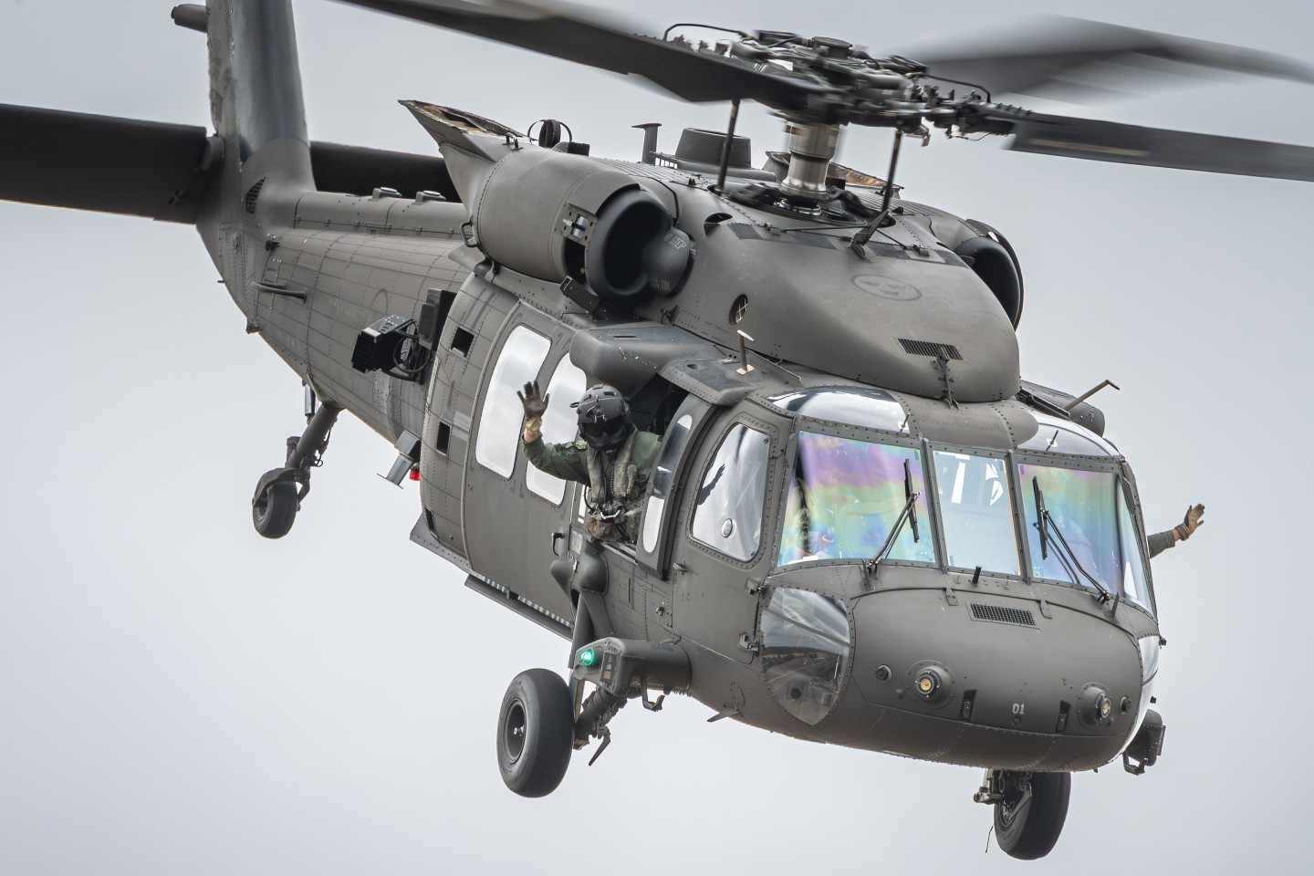 Pilots of a Sikorsky UH-60 Black Hawk helicopter of the Swedish Air Force waving goodbye to the crowd at the Royal International Air Tattoo 2025.