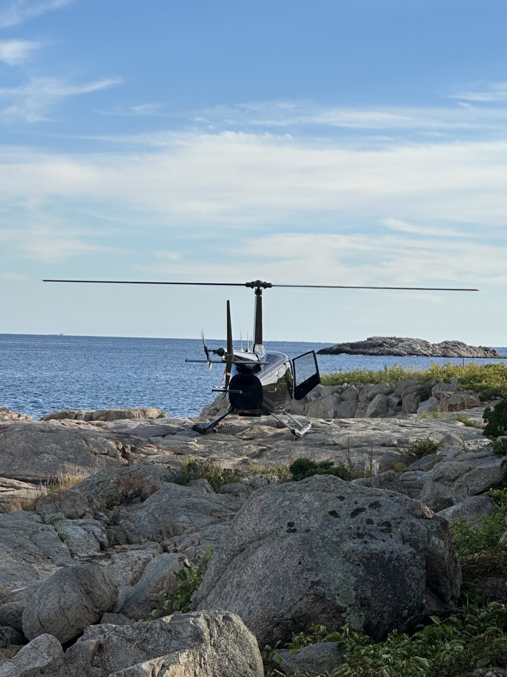 Landing on the rocks in our Robinson R66. Coast of Gloucester, Massachusetts.