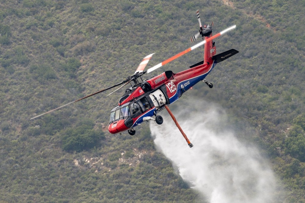 San Diego Gas and Electric's Blackhawk helicopter drops water on the Henderson Fire in Pala, California. It was quite difficult to get to this mountain location where we were above, or at eye level, as various aircraft dropped.  We had to go on private land and fortunately the owner gave us permission, and actually drove us to a better location in an all-terrain vehicle. Being able to photograph these highly skilled and brave pilots is such an honor and privilege.