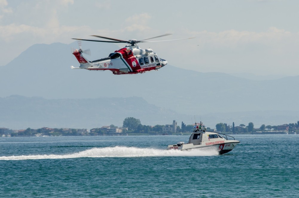 Leonardo AW139 "Coast Guard" callsign "Nemo" engaged in demonstration activities with a patrol boat inside Lake Garda, in front of the castle of Sirmione del Garda.