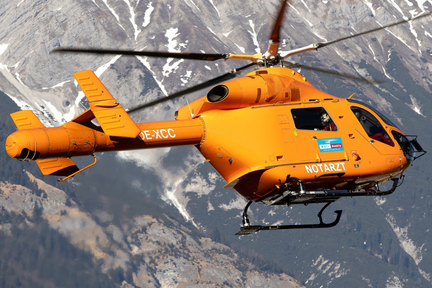 Notarzt Helicopter, OE-XCC McDonnell Douglas MD-900 Explorer, with Heli-Austria taking off from Innsbruck on its way to a mission. with a nice mountainous background.