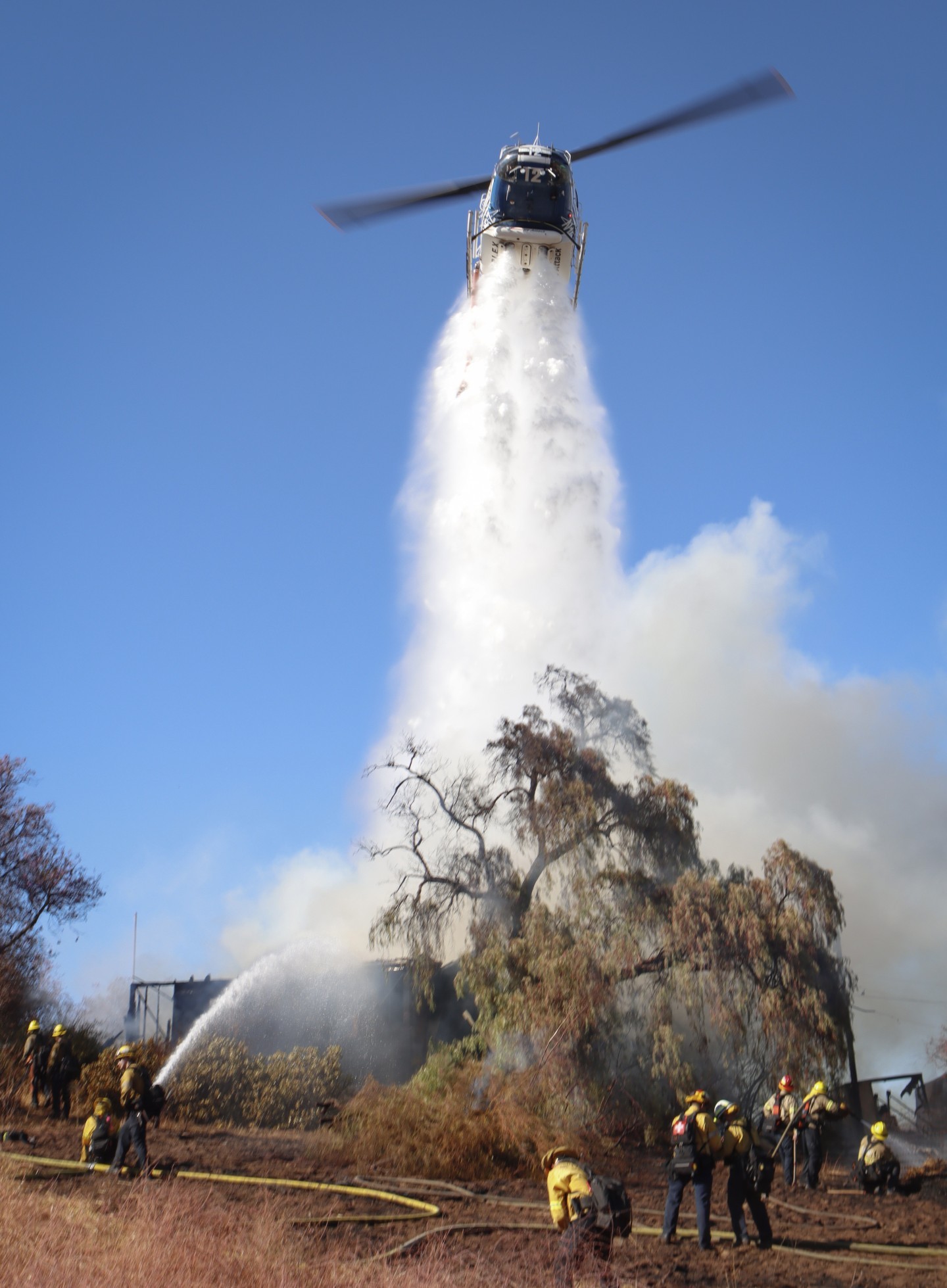 San Diego County Sheriff's Dept. Copter 12, assisting multiple agencies with making water drops onto homes while the ground crews work from below, during the Coches Fire in September 2025.