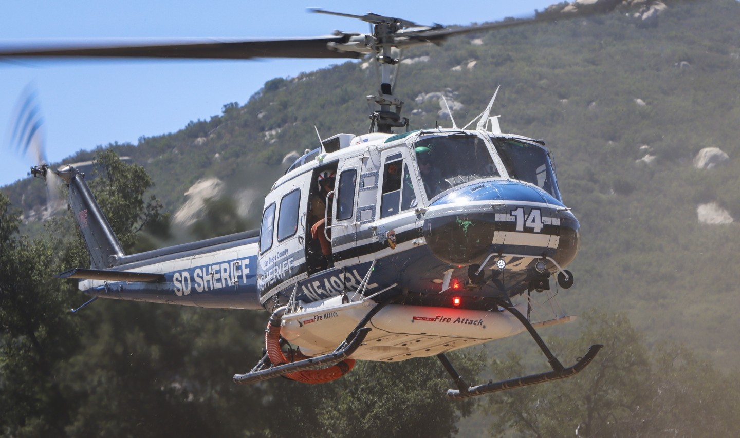 San Diego County Sheriff's Copter 12, departing an open dirt field after picking up the Gillespie helitack crews during the Springs Fire in July 2025.