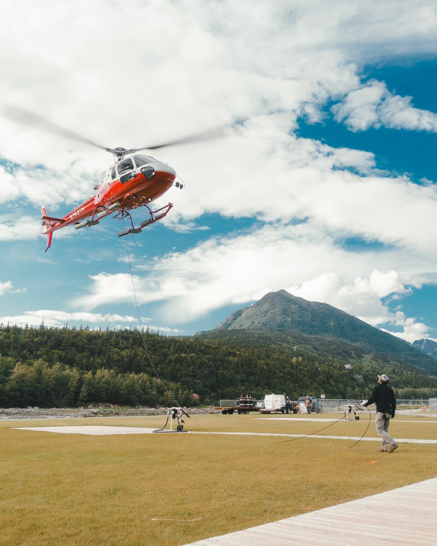Sometimes it's nice to have a helping hand on the ground. Ground crews help coil the line while this astar lands for more fuel during a sling job.