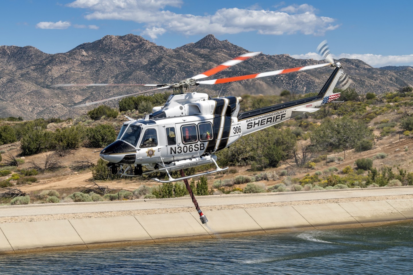 San Bernardino Sheriff's "Fire Attack" Bell 412 helicopter picks up water in the California Aqueduct to put on a prescribed burn near Silverwood Lake. I saw this beautiful background before he lifted off after taking in water and made sure, I composed my picture to include it with mountains and clouds. I hiked up a hill opposite the aqueduct so that I could photograph at eye level.