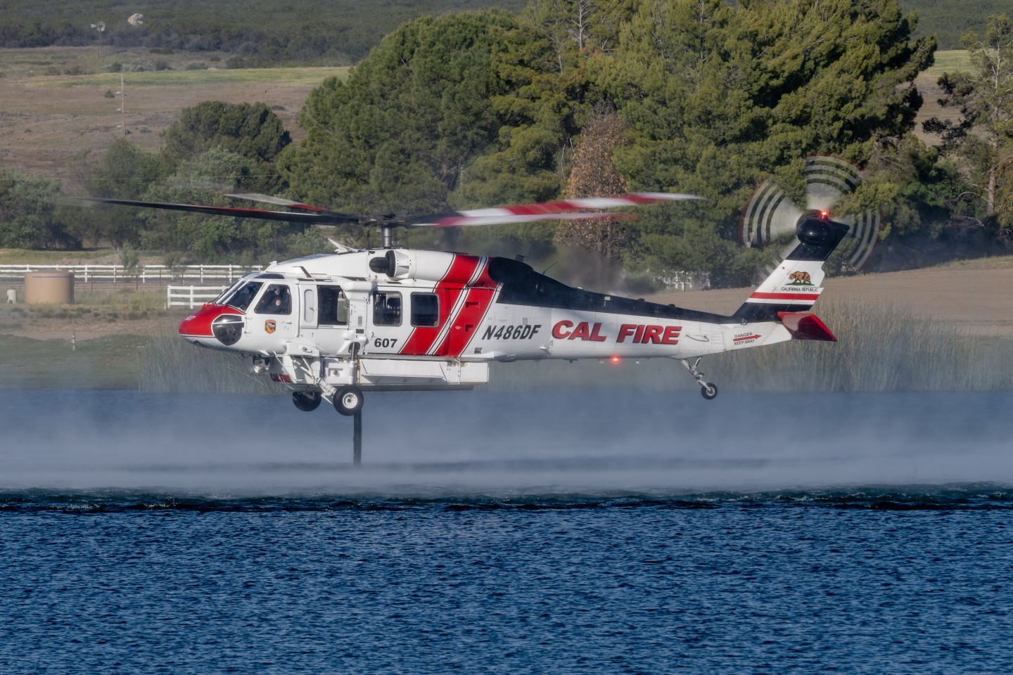 Cal Fire's Firehawk picks up water at Lake Riverside to drop on the Crossing Fire in Aguanga, California. We had to get permission to go on this private land, which allowed us great views of the various helicopters picking up water.