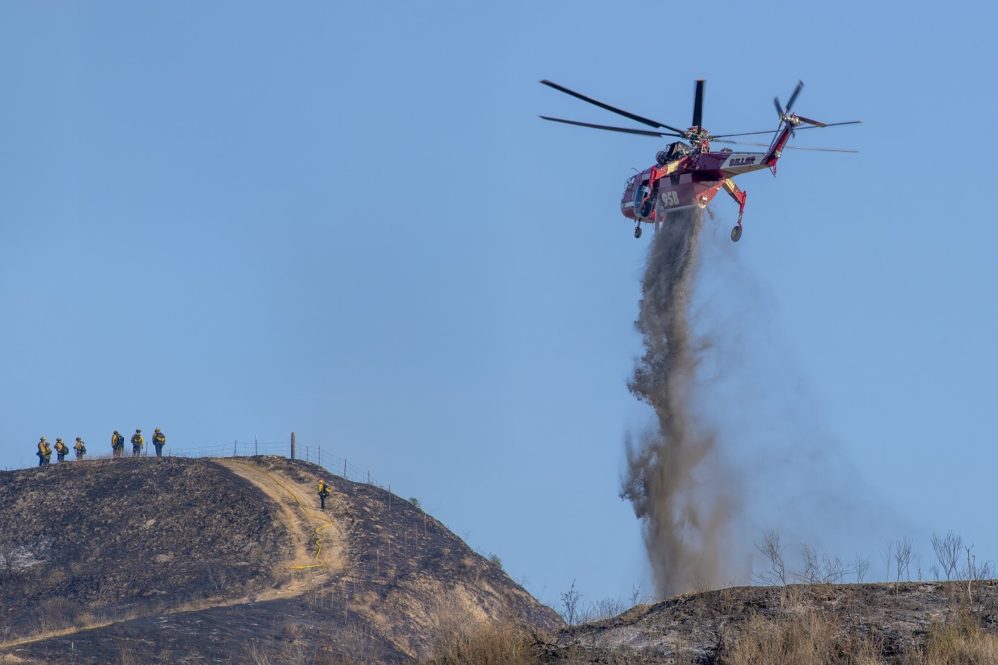 A Siller Skycrane helicopter (now Helicopter Express) drops water on the Oak Fire near Redlands, California. The fire was almost out and various helicopters were dropping on the last remaining hot spots.