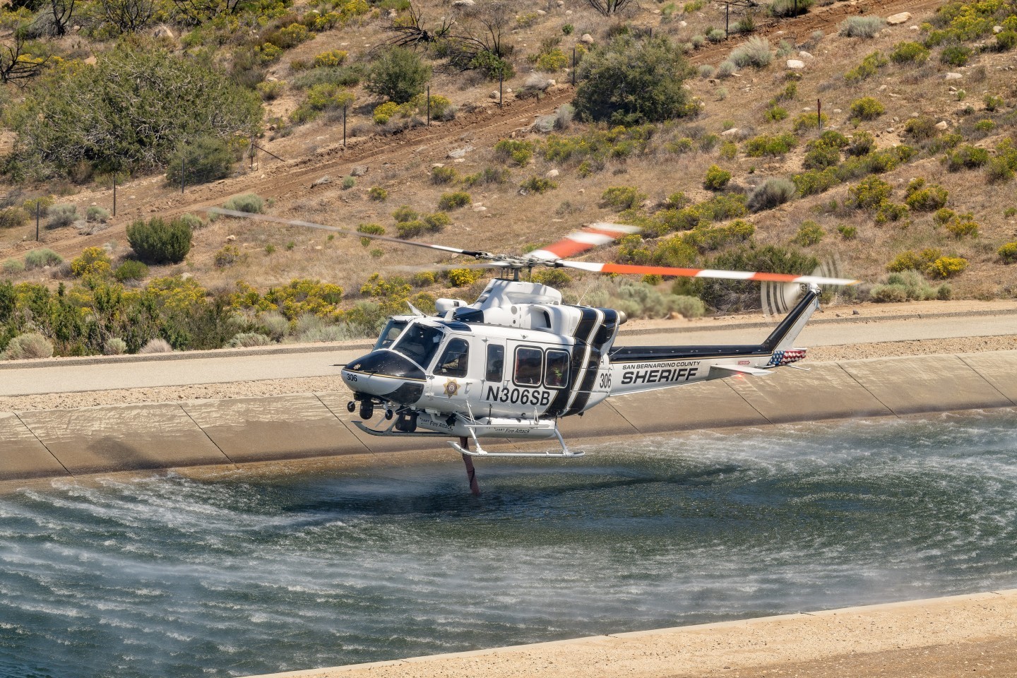 San Bernardino Sheriff's "Fire Attack" Bell 412 helicopter picks up water in the California Aqueduct to put on a prescribed burn near Silverwood Lake. I hiked up a hill opposite the aqueduct so that I could be above or at eye level as I photographed