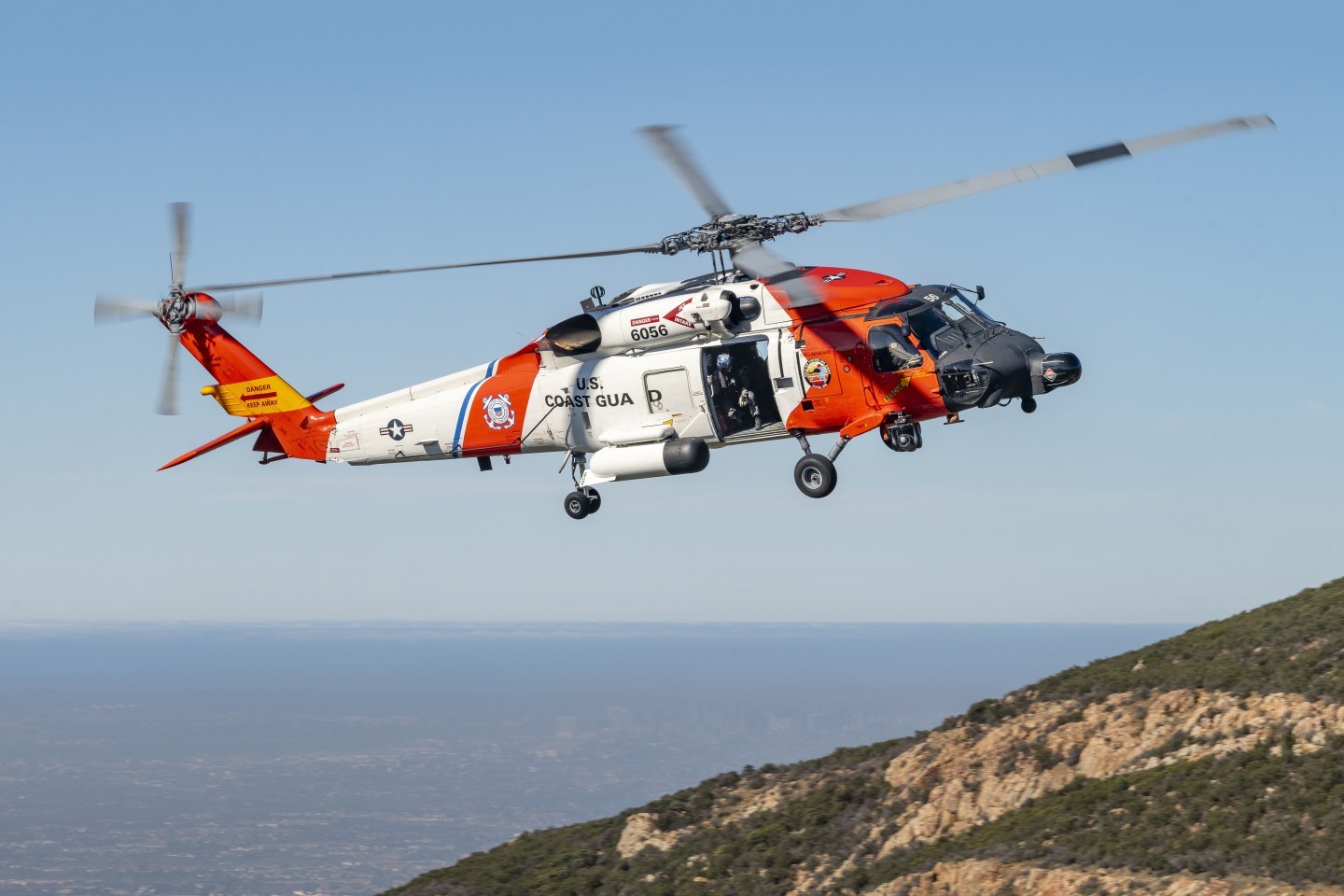 I did a special shoot of the United State Coast Guard Sikorsky MH-60T Jayhawk helicopter on the Otay Mountains in San Diego County, California. We got permission to drive on a BLM land dirt road which got me near the top of mountain. I then hiked up a brush filled hill to get to the right location. The road driving up was very bumpy and close to extremely steep drop offs. In the background are the cities of Otay Mesa and San Diego.