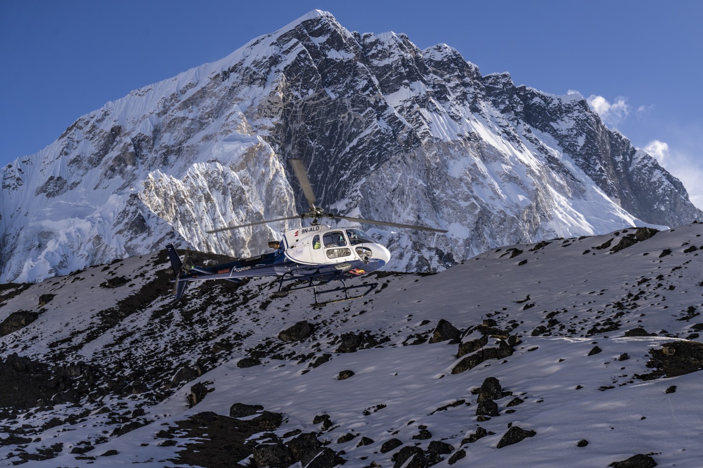 A helicopter picking up clients from a small village in the Everest region of Nepal in the early houses of the morning. The village is called Lobuche which is situated at 4940m. The mountain in the background is called Nupste.