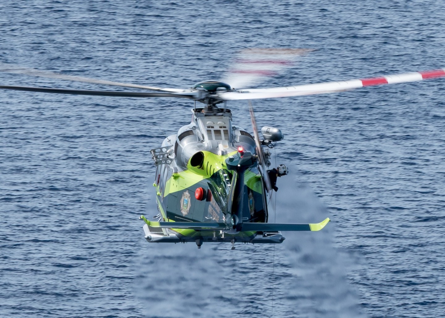 Miami Dade Fire Rescue's Air Rescue 4s hoist operator keeping a watchful eye on a freshly inserted diver during a training session near Miami Beach FL