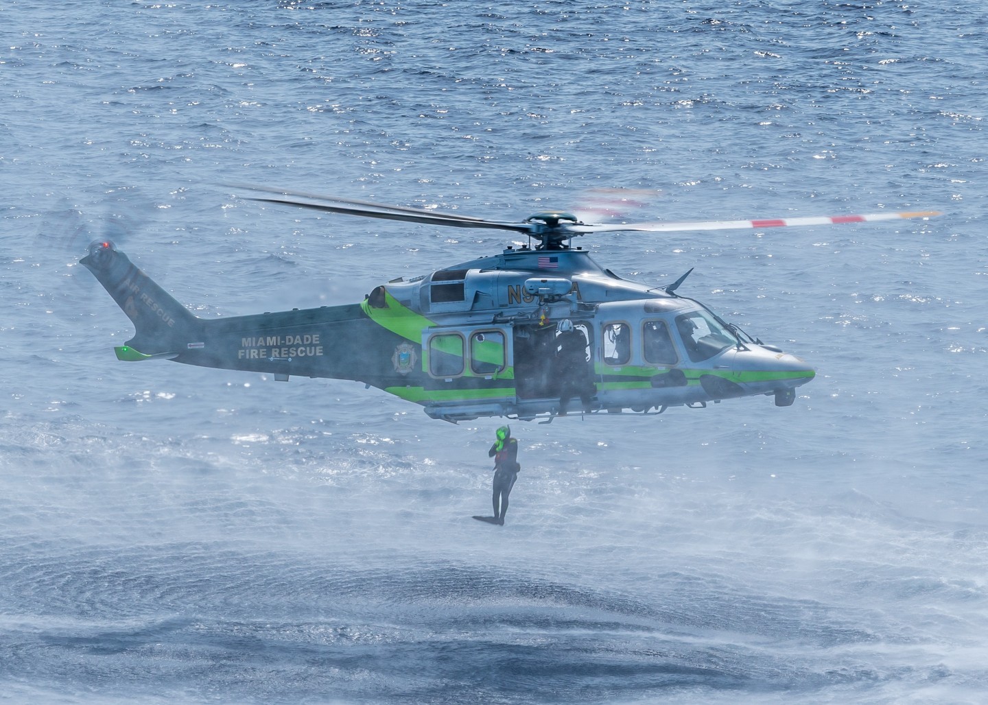 Diver away! Miami Dade Fire Rescue's Air Rescue 4 inserting a rescue diver during a training exercise near Miami Beach FL.