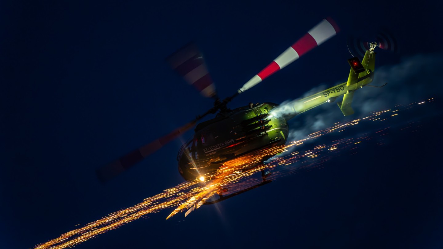 The photo was taken at the Sanicole Sunset Airshow 2025 in Belgium, capturing the Polish Bölkow Bo-105 helicopter flown by veteran pilot Maciej Dominiak. Once a German Army attack helicopter, now reborn as a spectacular airshow performer, the Bo-105 shows breathtaking agility and precision. During the display, it lights up the evening sky with fireworks, blending technical mastery, pilot skill, and pure visual drama.