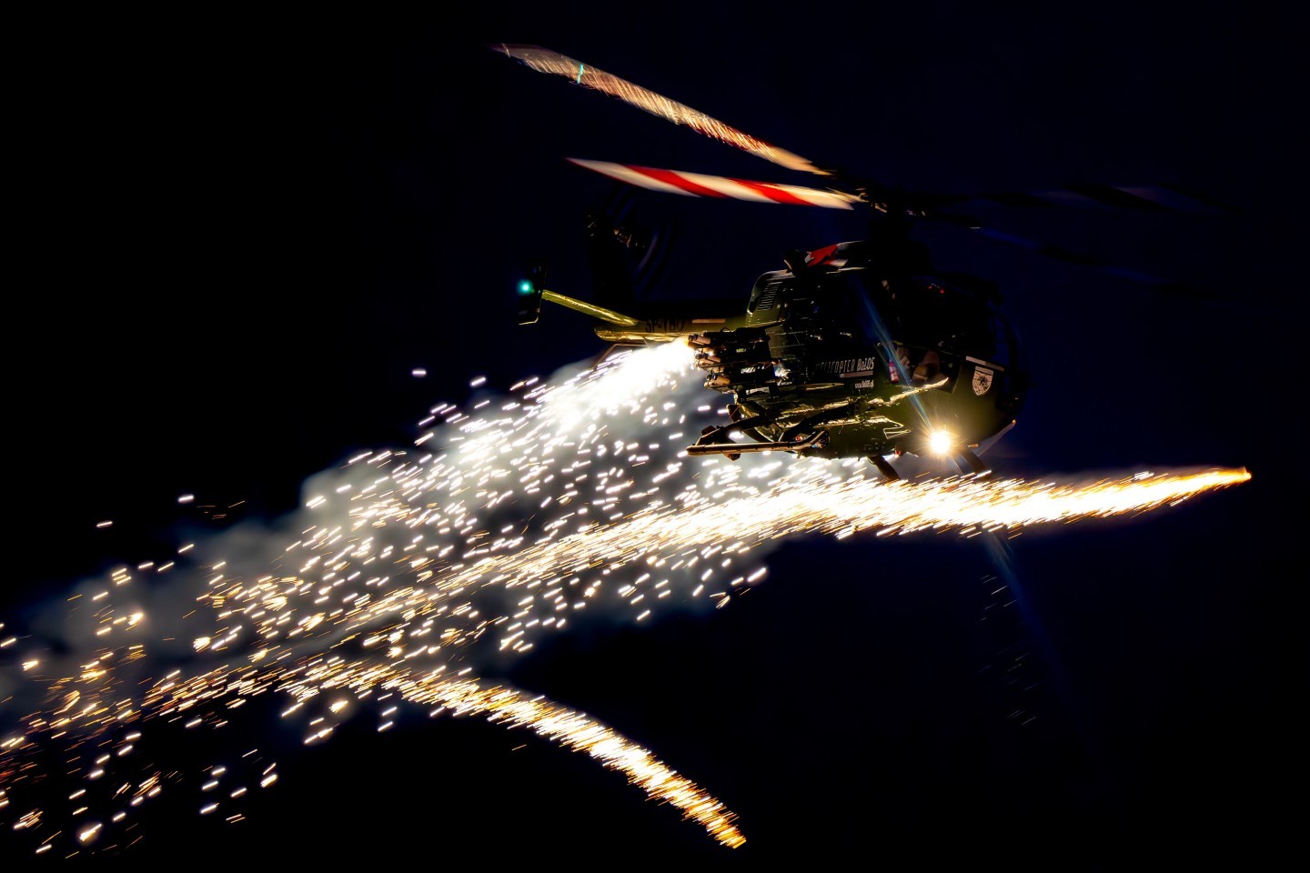 The photo was taken at the Sanicole Sunset Airshow 2025 in Belgium, capturing the Polish Bölkow Bo-105 helicopter flown by veteran pilot Maciej Dominiak. Once a German Army attack helicopter, now reborn as a spectacular airshow performer, the Bo-105 shows breathtaking agility and precision. During the display, it lights up the evening sky with fireworks, blending technical mastery, pilot skill, and pure visual drama.