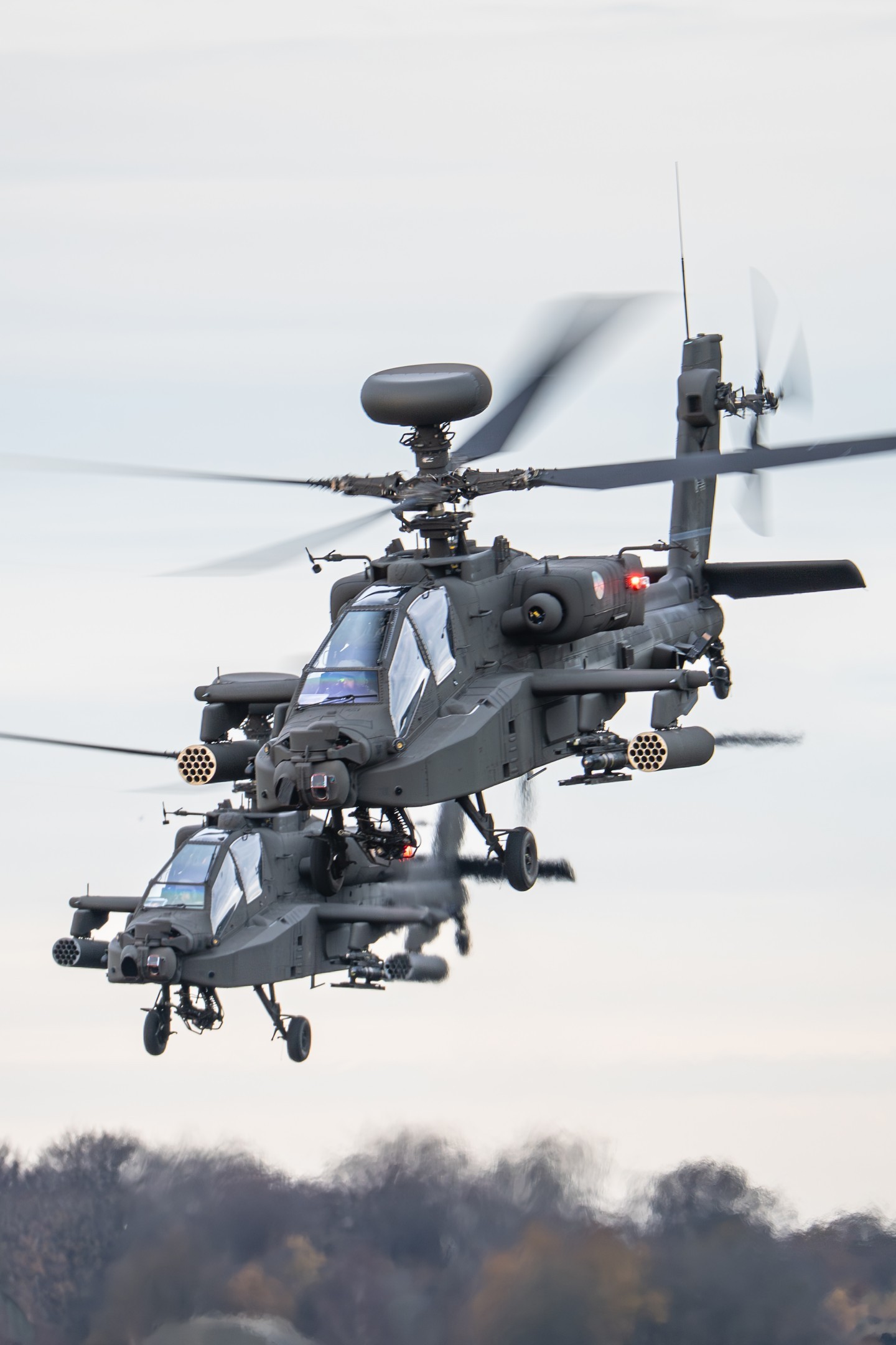 Two Boeing AH-64E Apache attack helicopters from the 301 Squadron of the Royal Netherlands Air Force leaving the Gilze-Rijen Air Base for another training mission.