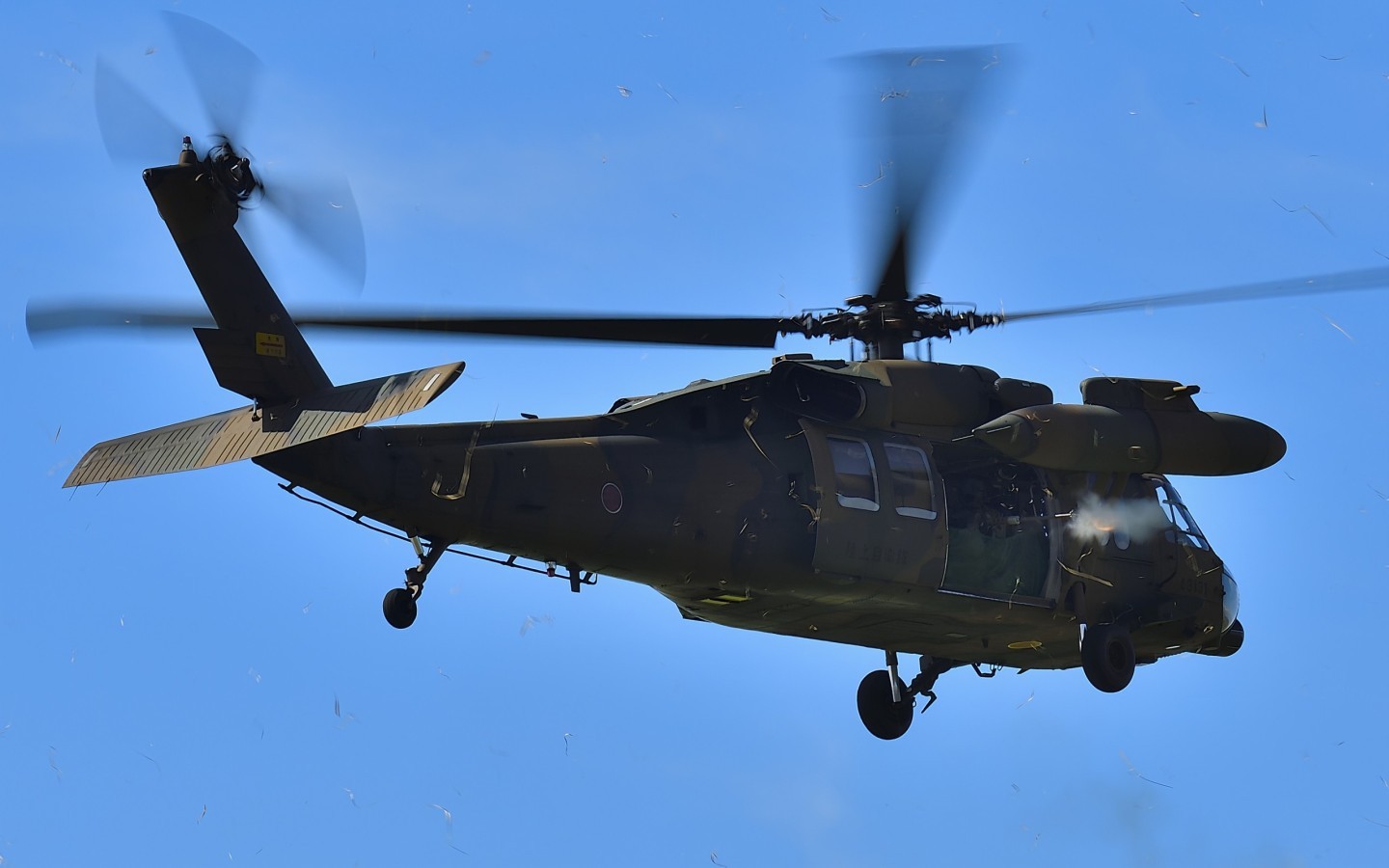 Scattering dried grass with its downwash, UH-60JA of JGSDF was demonstrating a blank firing of .50 Cal in Kisarazu Airshow.