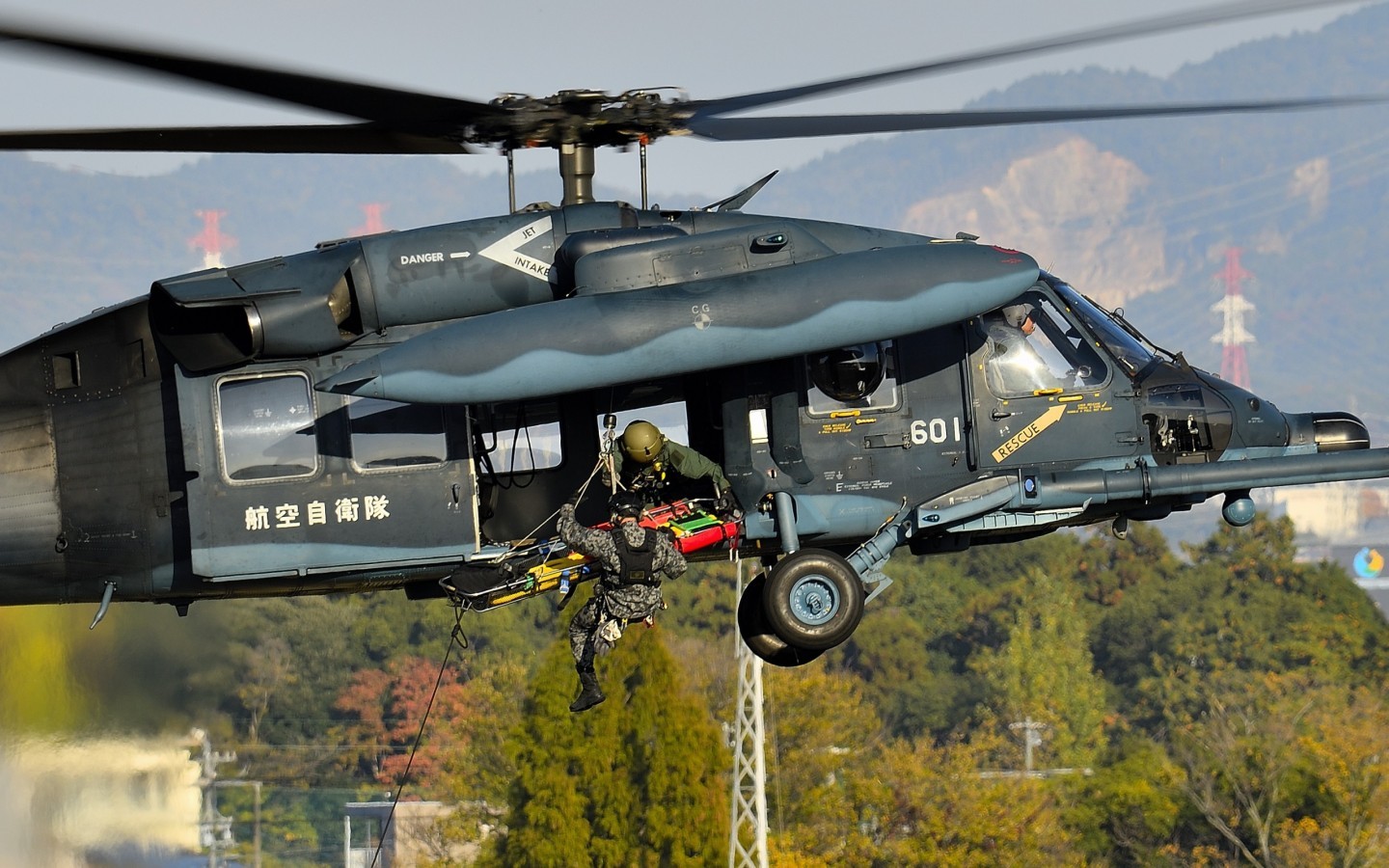 JASDF FE on UH-60J Blackhawk were hoisting PJ and his stretcher during SAR demonstration in Komaki Airport.
Another PJ on ground supported the stretcher with a string to stabilize it.