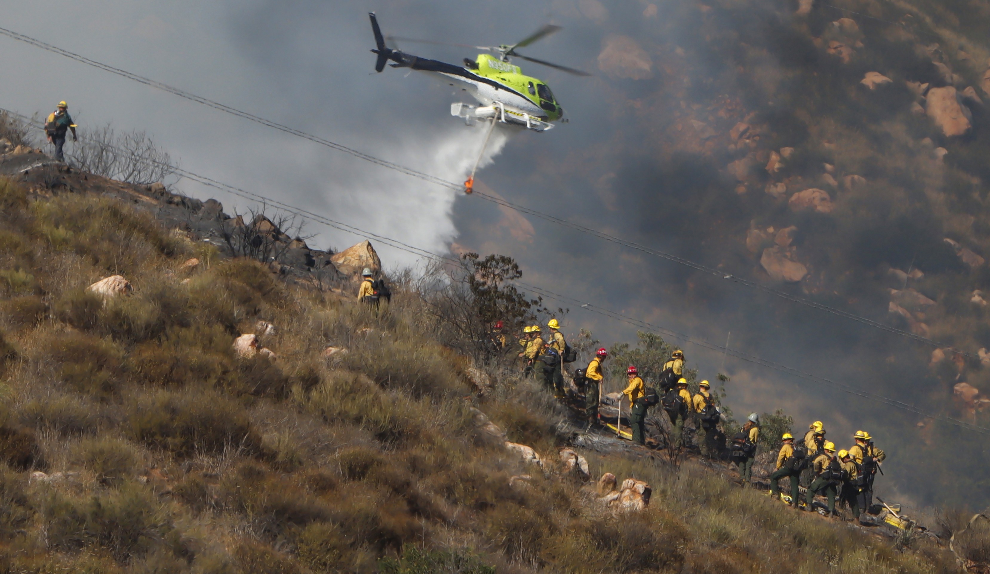 An Air Resources Helicopters Airbus H125 operating by USFS Keenwild Helitack 535, assisted CAL FIRE with numerous water drops, helping firefighters attack the Monte Fire in Lakeside, CA in June 2025.