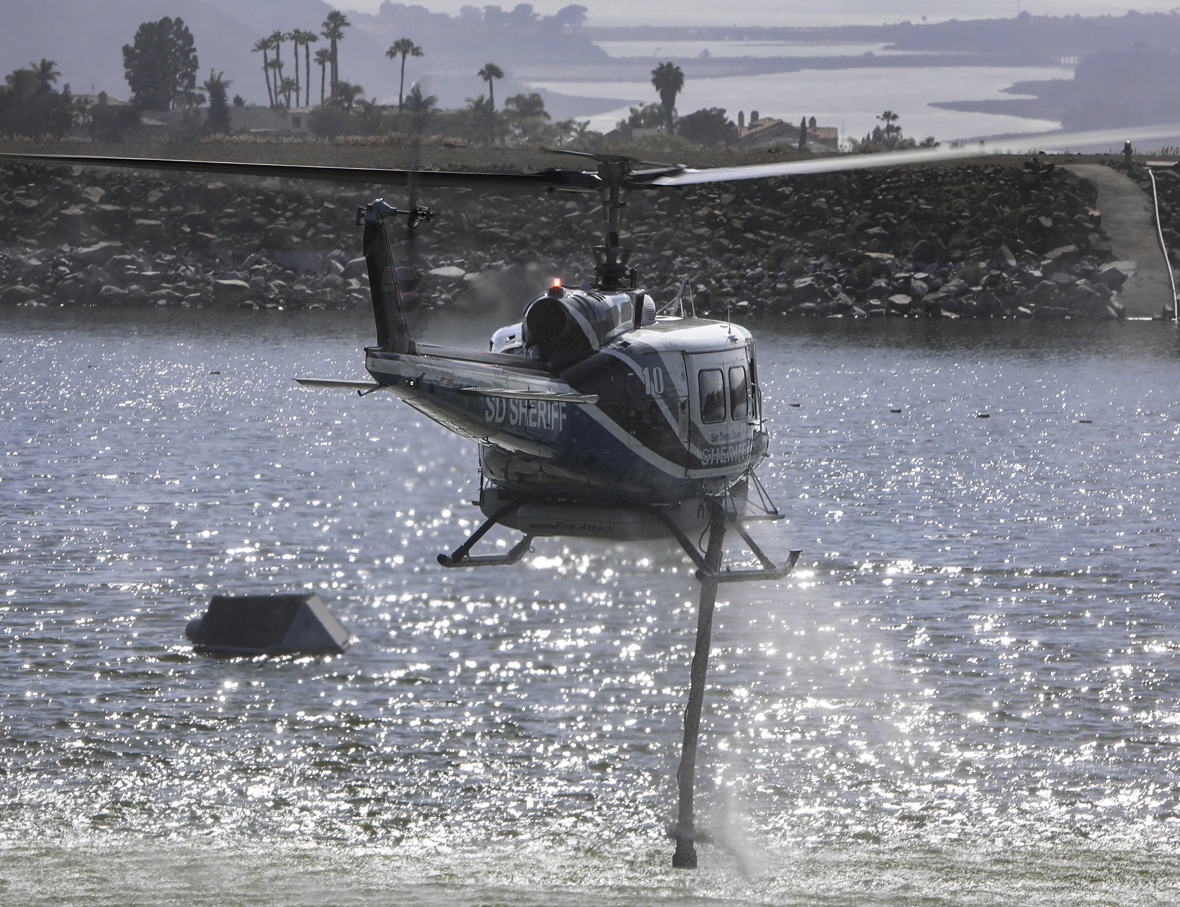 Copter 10 operated by the San Diego County Sheriff's Dept. departs an unnamed reservoir in the Carlsbad, CA area during the Claro Fire in June 2025.