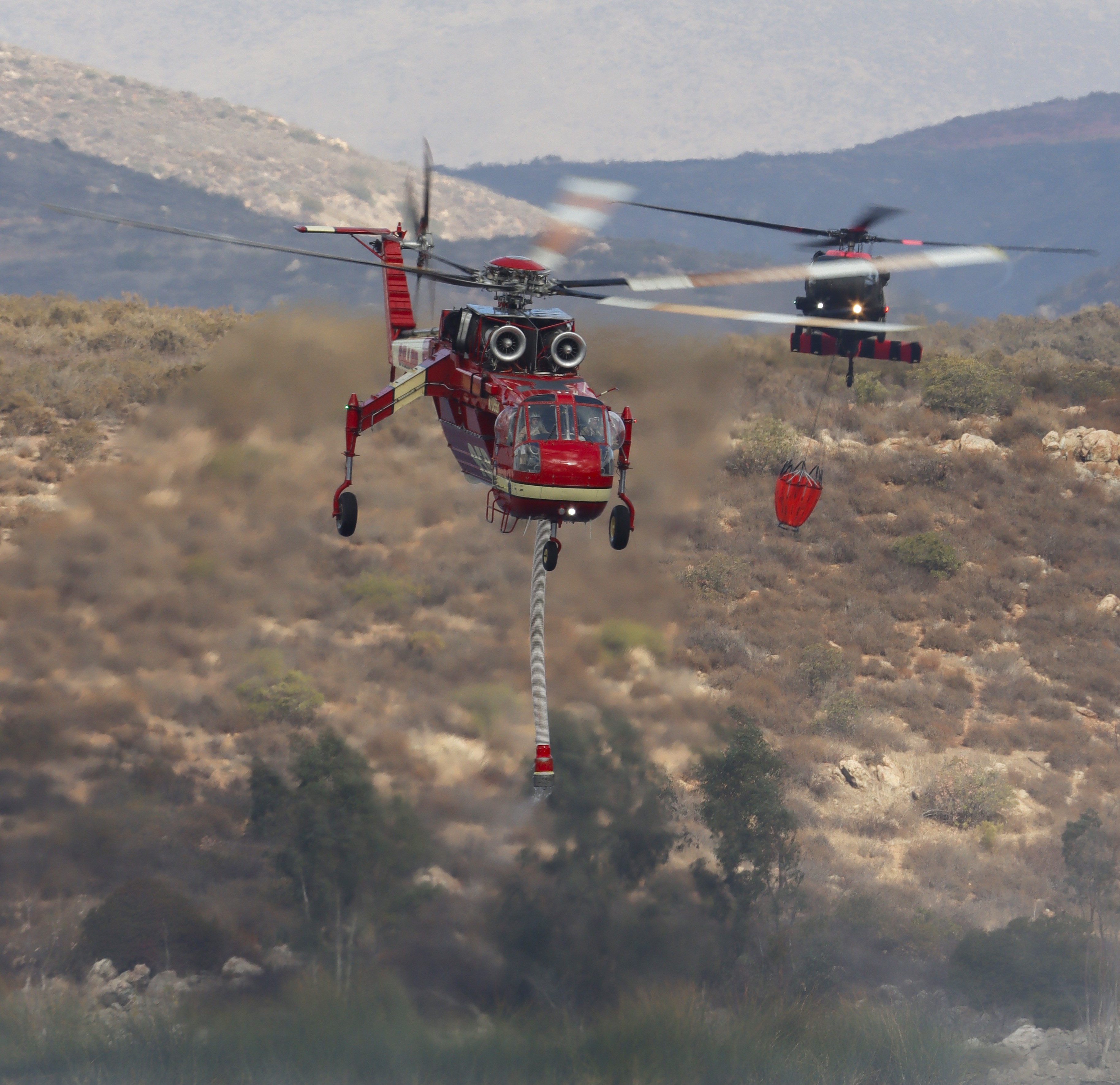 Siller Helitanker 95B shadowed by Army Nat'l Guard Copter 836, while departing Otay Lakes in Chula Vista, CA during the Border 2 Fire burning in the Otay Mountain Wilderness.