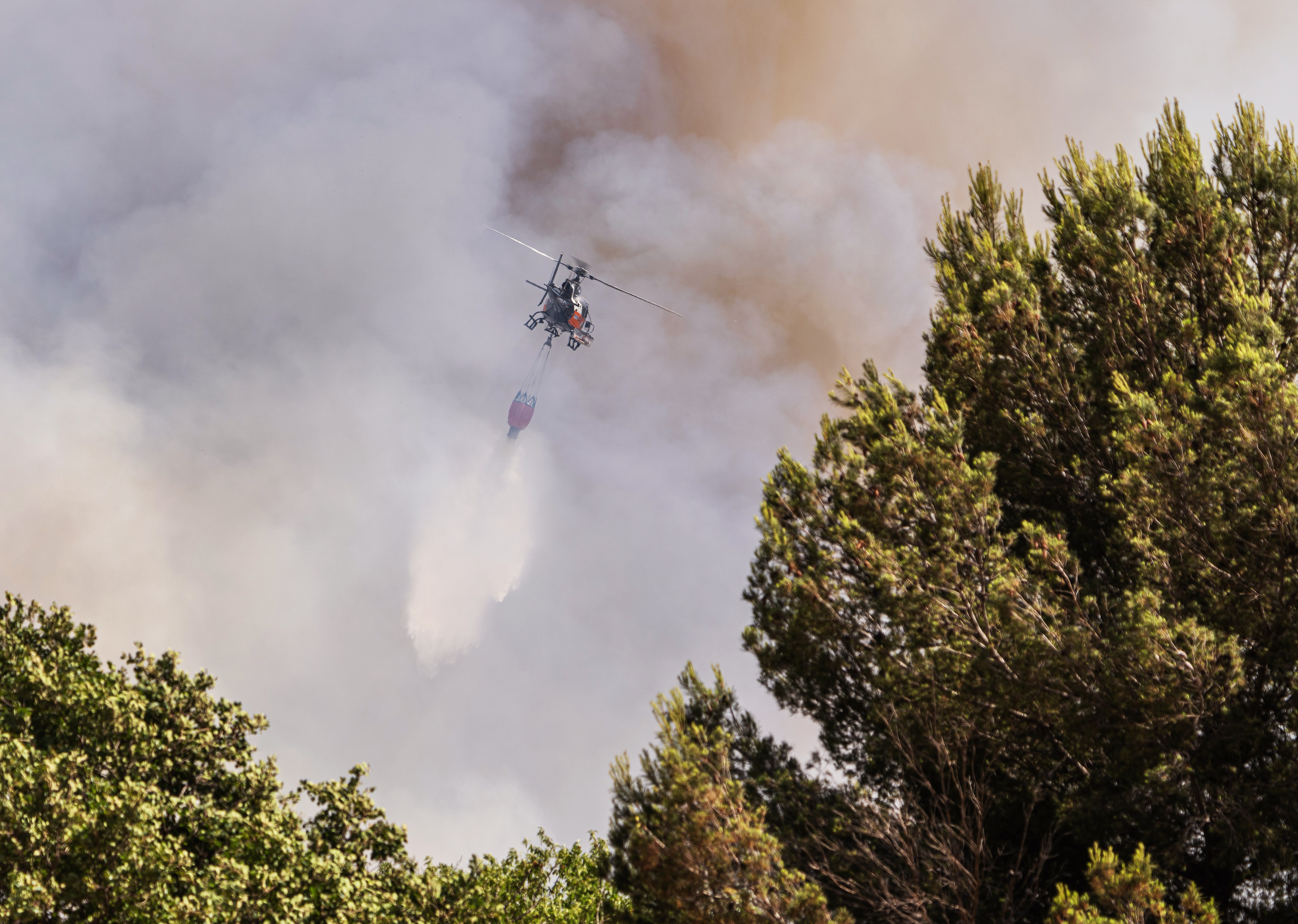 An Écureuil helicopter drops water during the fire in Saint-Victoret, Bouches-du-Rhône, France.