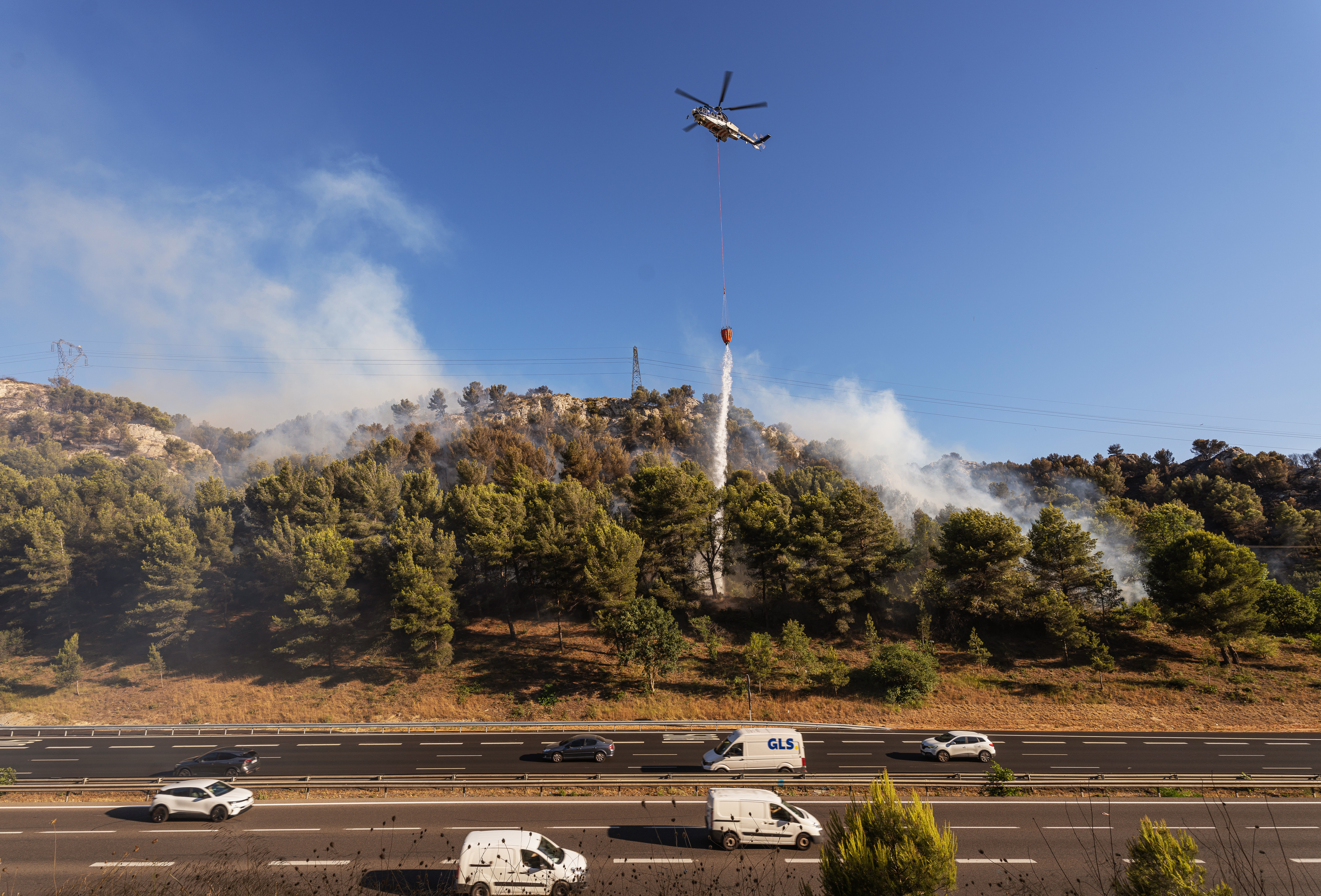 An Super Puma helicopter drops water during the fire in Les Pennes-Mirabeau, Bouches-du-Rhône, France.