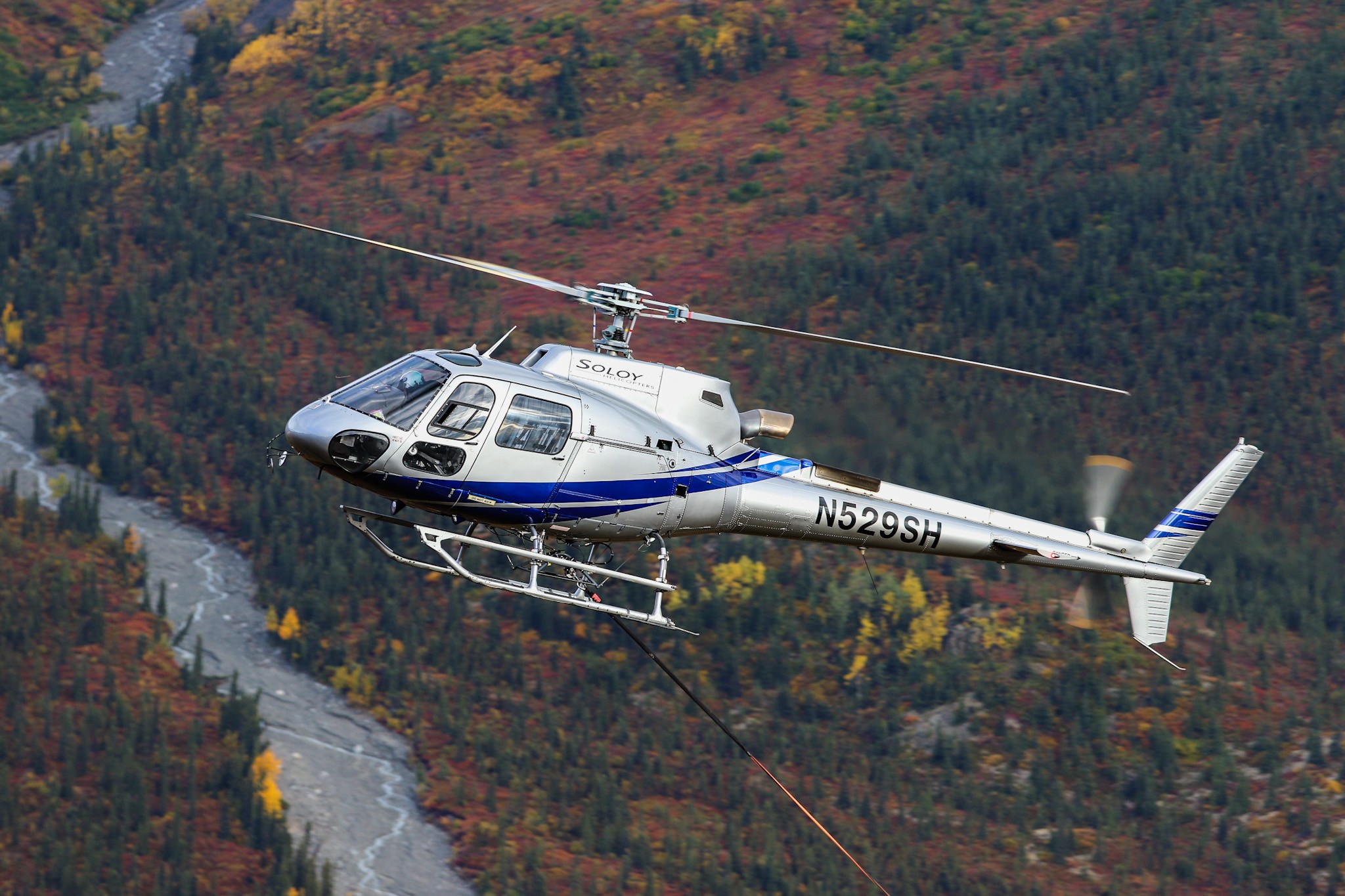 AS350 long lining at a drill site, somewhere in the eastern Alaska Range mountains, with the beautiful September foliage back drop.